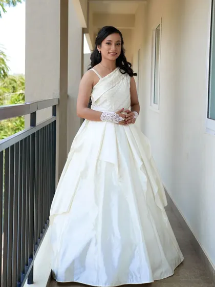 Our bride posing elegantly on her wedding day, wearing the custom white gown we designed together to make her feel special.