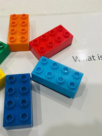 A close-up of the six colorful Lego bricks used in the training program, a simple tool for endless learning possibilities.