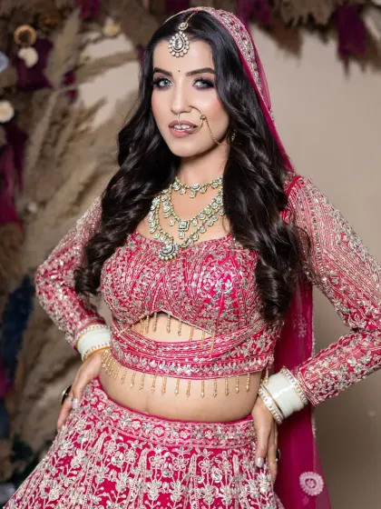 A full-length view of a bride in a gorgeous pink lehenga. The makeup is designed to look stunning from every angle, ensuring you are picture-perfect on your big day.