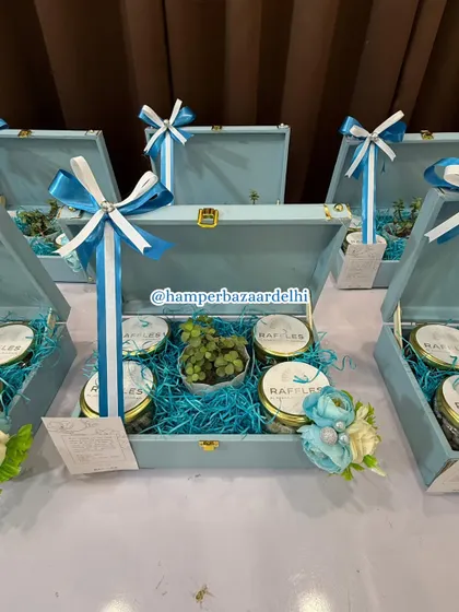 A close-up of the custom corporate hampers for Raffles. The cool blue box, matching shredded paper, and coordinated ribbons were all chosen to align with the client's brand colors.