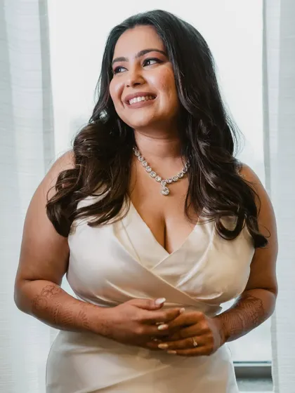 A happy and confident bride. The makeup is classic and timeless, perfect for her elegant white gown.