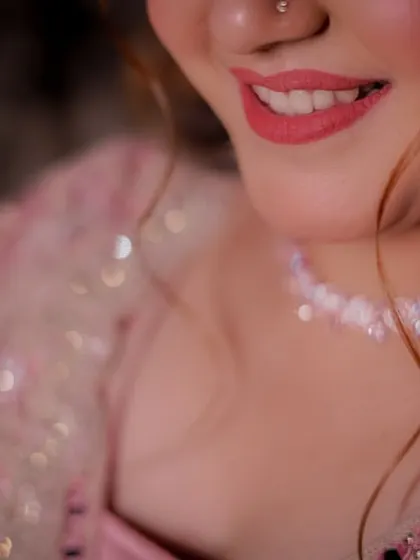 A close-up on the bride-to-be's smile and her delicate, sparkling necklace, capturing the fine details of her engagement look.