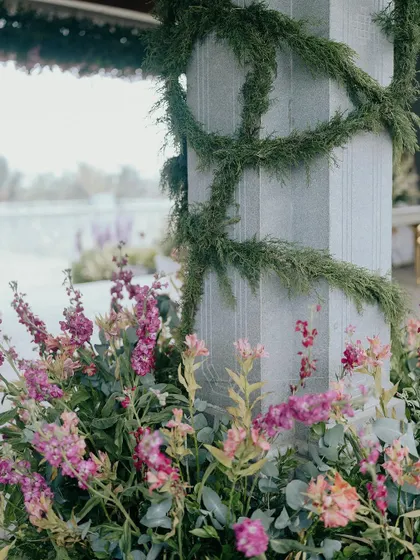 A close-up of the floral and greenery details from Nithya and Payton's wedding. We love layering different textures and colors, like these soft pink snapdragons against the cool stone pillar wrapped in delicate vines.
