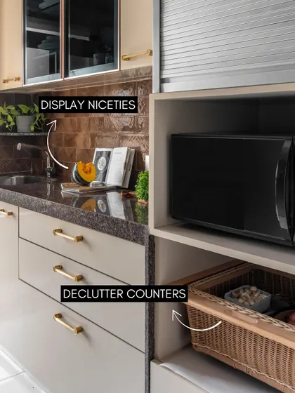 This image provides great tips for kitchen styling. Decluttering counters and using baskets for storage keeps the space tidy, while displaying nice ceramics and cookbooks adds a personal touch.