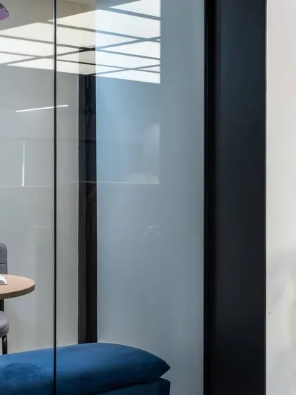 This small, glass-enclosed pod offers a quiet space for focused work or private calls, balancing the needs of collaboration and individual concentration in a modern workplace.