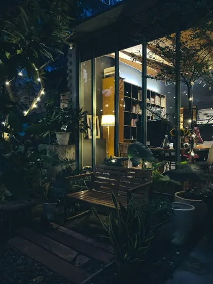 Our studio at night, illuminated from within. The warm light and surrounding plants create a welcoming and magical atmosphere, a place where ideas continue to grow even after dark.