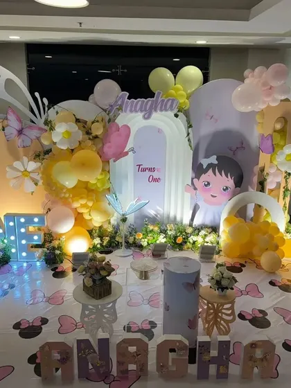 A whimsical garden party stage with a mix of butterfly and floral elements, perfect for a first birthday.