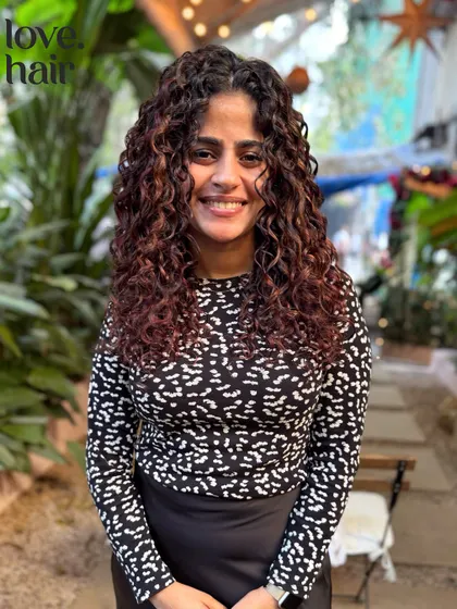 The client looking radiant with her freshly colored and styled curls. Our goal is to make your natural texture shine.