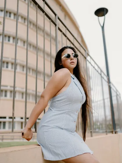 A full-length portrait of a model in a stylish dress, with the city buildings in the background. This shot combines fashion with an urban landscape.