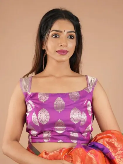 This sleeveless purple brocade blouse features a silver leaf motif, offering a regal and elegant look.