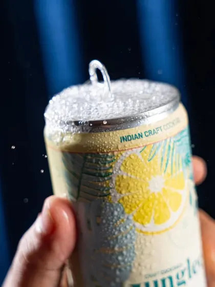 A close-up action shot of a Junglee can being opened, with a spray of fizz. This macro shot emphasizes how refreshing and crisp the drink is.