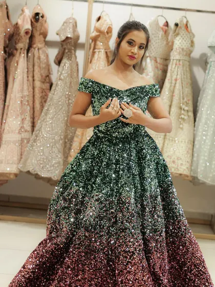 A full-length shot showing the entire gown against a backdrop of other dresses, giving a behind-the-scenes feel of a designer studio.