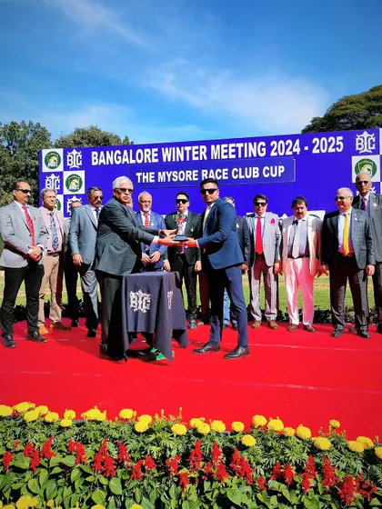 Mr. H.K. Ramesh from Mysore Race Club presents the cup to the winning owner.