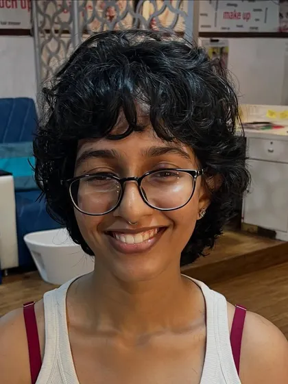 A short curly shag haircut, perfect for someone wanting a stylish, low-maintenance look.