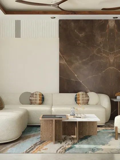 This living area in DLF Phase 2 features an organic theme. The round L-shaped sofa and Japandi-style armchair are complemented by a bold marble accent wall, bringing nature-inspired luxury indoors.