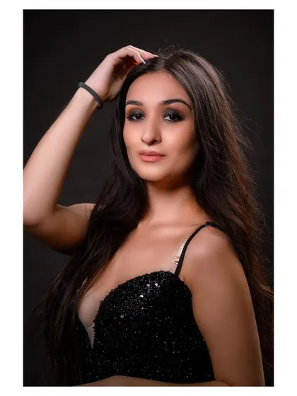 A glamorous studio portrait in a sparkling black dress. The model's pose is elegant and sophisticated.