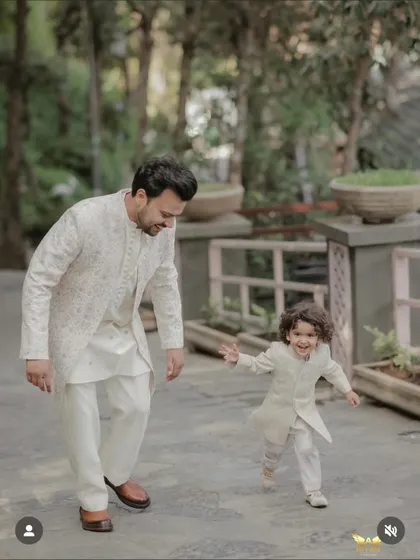 Capturing a beautiful moment between a father and son, both dressed in our coordinated off-white sherwanis. We specialize in creating matching traditional outfits for the entire family, ensuring everyone looks their best.