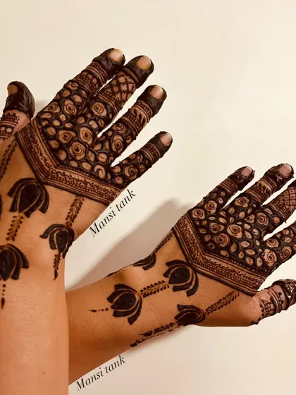 A modern take on traditional motifs. This design features bold lotus flowers on the back of the hands, paired with a dense rose pattern on the fingers.