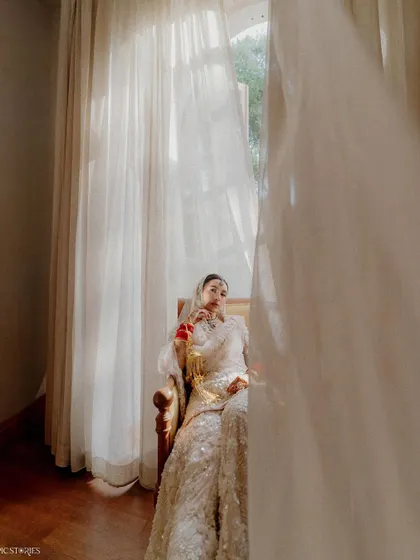 A creative use of foreground to add depth to a bridal portrait. The flowing curtain creates a sense of intimacy, as if we are getting a private glimpse of the bride in a quiet moment.