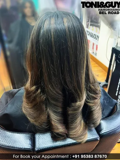This client's long hair was cut with soft, blended layers and styled with an inward curl for a polished finish. This technique helps to add shape and reduce bulk in thick hair.
