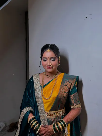 A full view of the bride's look, showcasing the rich colours of her saree and the classic elegance of her makeup and hair.