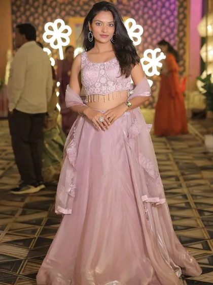 A client posing in the lavender lehenga at an evening event.