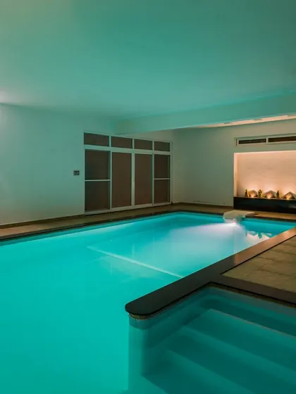 The indoor swimming pool of the 10,000 sq. ft. residence in Bangalore. The space is designed as a serene sanctuary, with calm lighting and clean lines creating an ocean of serenity.