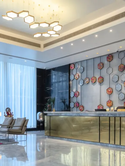 The reception area at Hotel Sarovar Portico, Gujarat, where we integrated local art forms into the design. The backdrop is a fusion of Kutch embroidery and Lippan art arranged in a honeycomb pattern, which is also reflected in the ceiling lights.