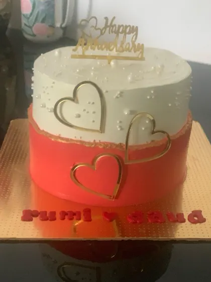 A modern two-tone anniversary cake. The design features clean lines and elegant gold heart outlines for a contemporary romantic feel.