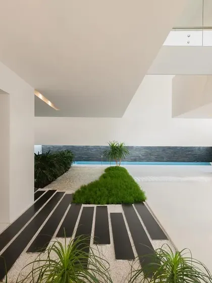 A view from the elevator at the Neeti residence, looking across the indoor garden path towards the swimming pool. This perspective shows how we layer spaces and materials to create depth and visual interest.