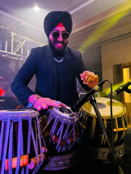 In the zone, playing tabla with a smile. I feed off the energy of the crowd during my live DJ fusion sets.