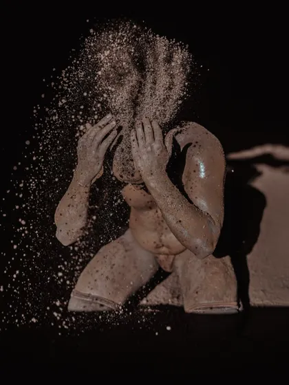 Two highly artistic shots of a wrestler with soil exploding around his face. These images capture the dynamic and elemental nature of wrestling in the mud pit.