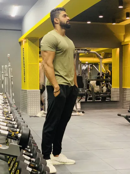 Standing in my element at the gym. This is where the work happens. A relaxed stance still shows the posture and presence that comes from years of strength training.