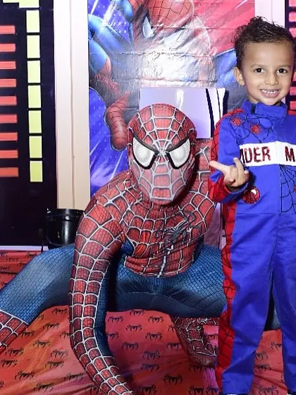 The birthday boy posing with his hero, Spider-Man. Arranging for a character mascot to interact with the kids is one of the best ways to make the theme feel real and create unforgettable photo opportunities.