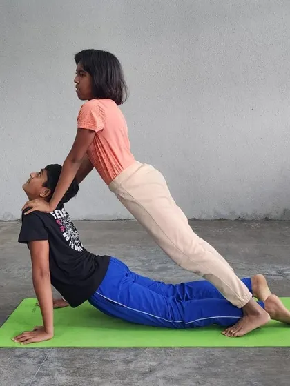 We guide our campers through assisted stretches like this modified cobra pose. It helps deepen the stretch safely, improving back flexibility while relying on a partner for support.