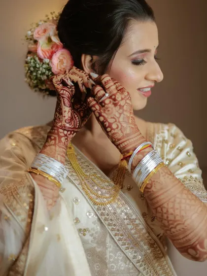 A close-up of the bride getting ready, putting on her earrings. We focus on these small, significant moments.