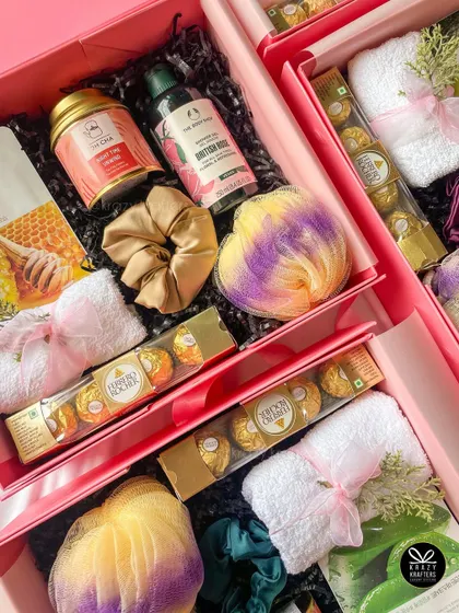 A soft and soothing pamper hamper for her, with honey and aloe-themed skincare, bath bombs, and Ferrero Rocher chocolates.