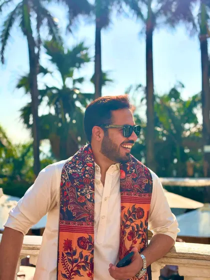 A candid, smiling shot in a Pathani suit with a printed shawl, enjoying the sunny outdoors at Taj Lands End.