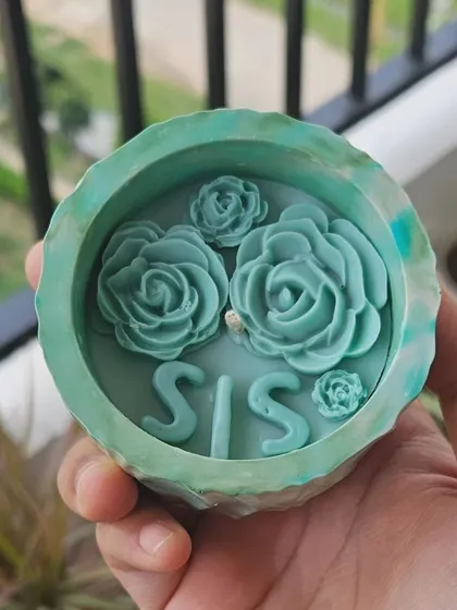 And of course, a matching Rakhi-themed candle for your 'SIS'. This one is in a beautiful teal eco-resin jar with wax roses on top. It's a perfect way to show your sister some love.