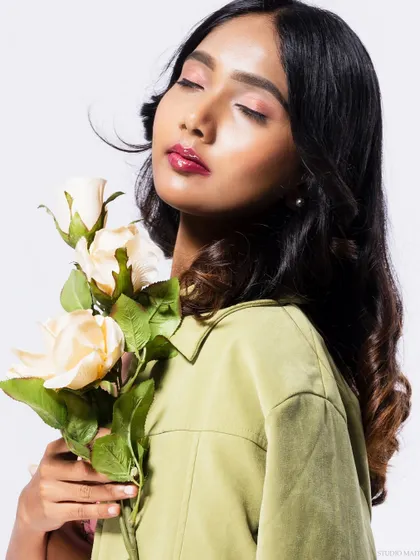 A serene beauty shot, with the model's eyes closed, smelling the roses.