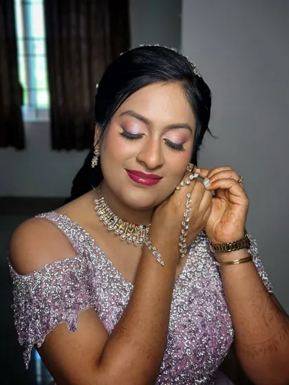 A candid moment of the bride getting ready. The makeup is designed to be picture-perfect, with a focus on glowing skin and eyes that sparkle.