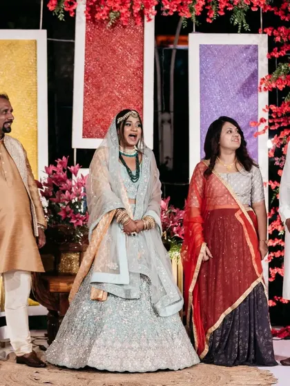 Family portraits against a vibrant backdrop. The colorful panels and bright red floral arrangements create a festive and cheerful setting for this pre-wedding celebration.