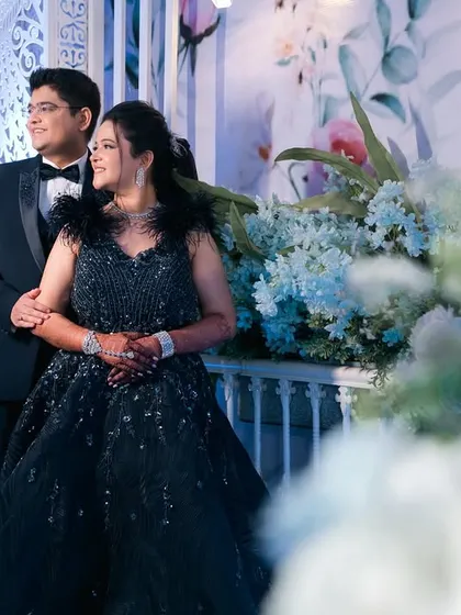 A grand reception portrait of a couple amidst beautiful floral decorations.