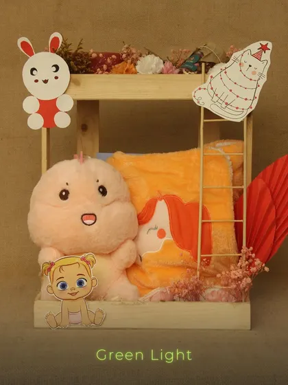 A cute and playful hamper for a child's gift. This wooden crate includes a soft plush toy and a character-themed towel, decorated with fun cutouts.