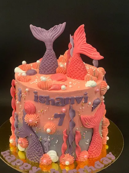 A beautiful mermaid themed cake for a 7th birthday. I used shades of pink and purple to create an underwater feel, with fondant mermaid tails and seashells.