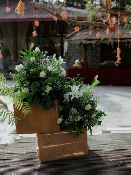 Rustic jute-covered boxes used as stands for floral arrangements, blending natural textures with elegant flowers.