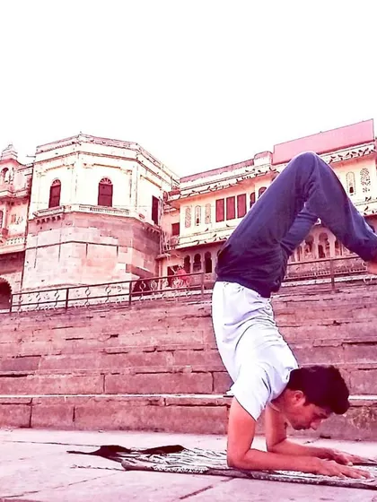 Vrischikasana, the Scorpion Pose, practiced at the Gangaur Ghat in Udaipur. This advanced inversion requires great strength and trust. It teaches us to overcome fear and find balance in challenging situations, transforming our perspective.