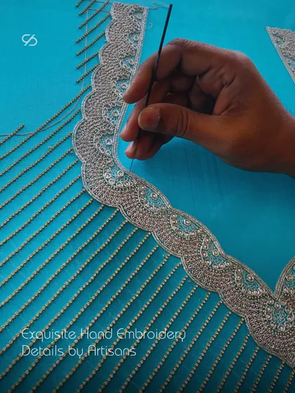 Exquisite hand embroidery details by my artisans. A hand is shown meticulously stitching the beaded border of a custom designer blouse, a testament to elevating your style with every stitch.