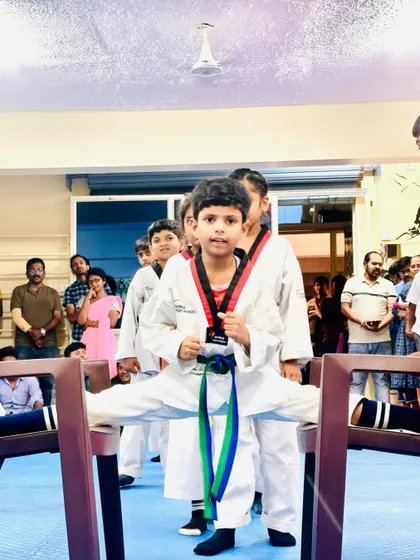Flexibility is as important as strength in Taekwondo. This student demonstrates incredible dedication and control, achieving a full split between two chairs.