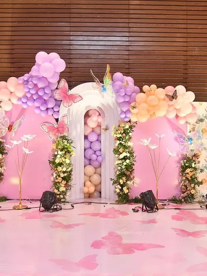 This grand setup for a baby welcome event features a stunning butterfly theme. I used a 3D panel arch filled with balloons and floral arrangements to create a breathtaking photo backdrop.